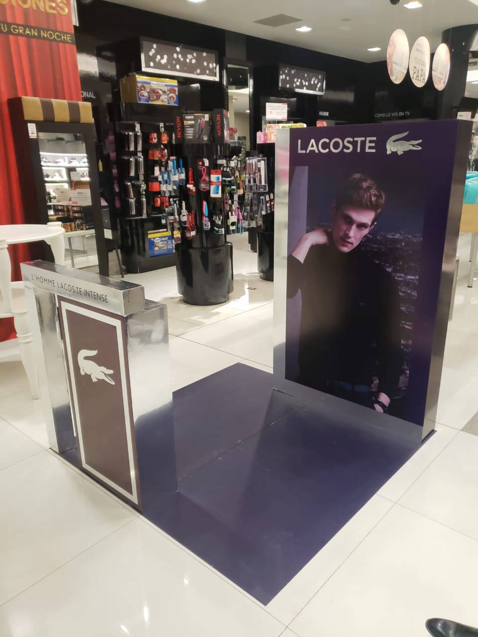 Stand publicitario premium de Lacoste para exhibición de perfumes en tienda departamental. ¡Atrae más clientes y aumenta tus ventas!
